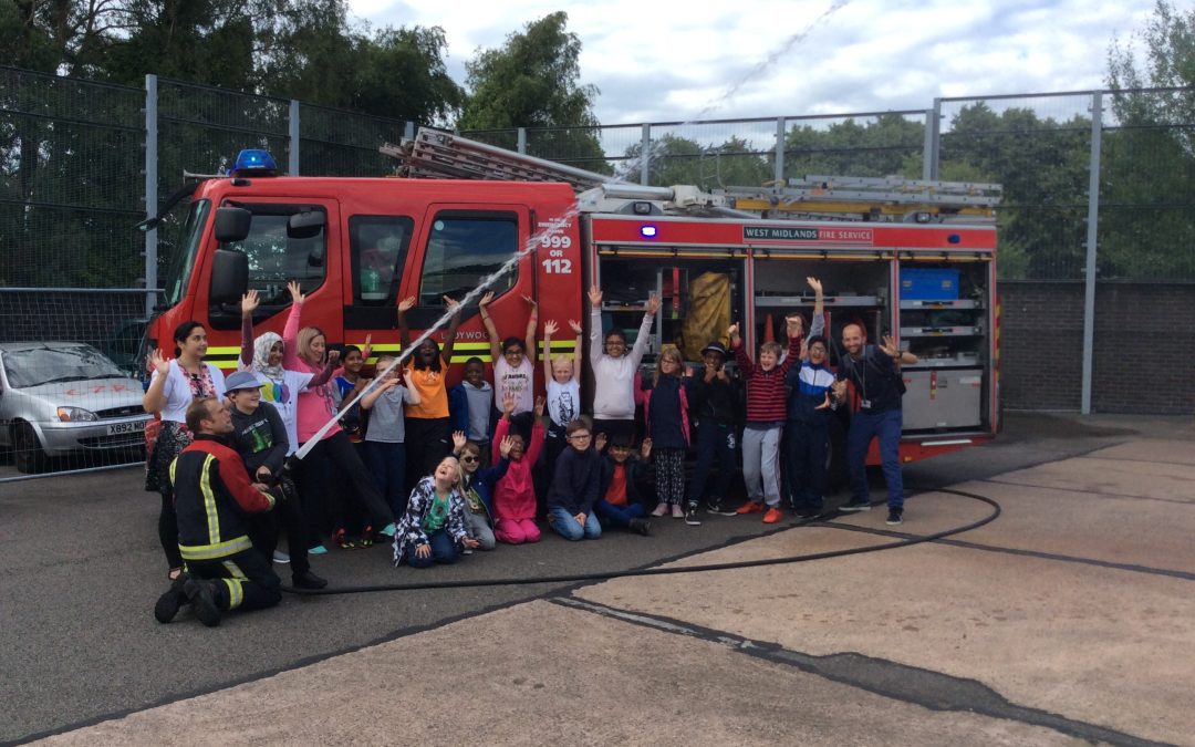 Group of young people smiling and standing in front of a Fire Engine